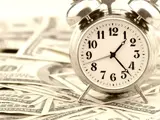 a clock on a pile of money